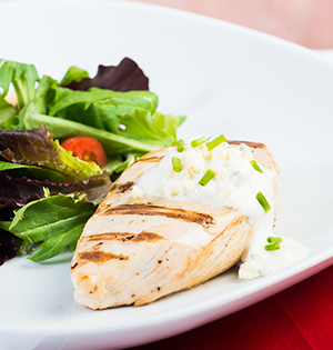 Poitrines de poulet grillées servies avec une sauce au fromage bleu